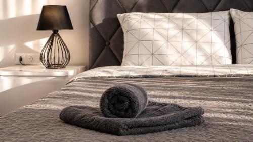 a bedroom with a bed with a gray blanket and a lamp at K-49 prie Jūros in Klaipėda
