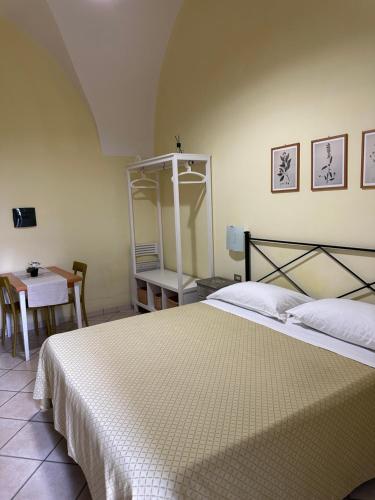 a bedroom with a white bed with a table and a table at Anfiteatro apartment in Formia