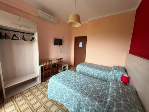 a room with two beds and a table and chairs at Albergo Maria Cristina in Esperia
