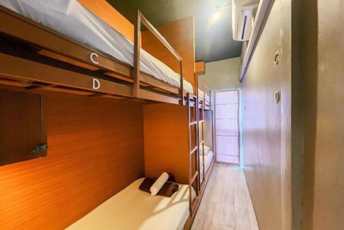 a small room with bunk beds and a hallway at Loftel 22 Hostel in Bangkok