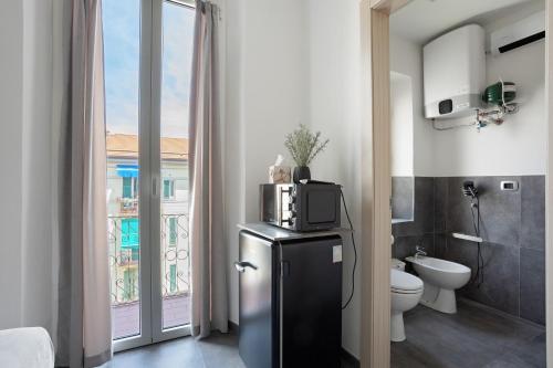 a bathroom with a refrigerator and a toilet and a window at Domi Home in La Spezia