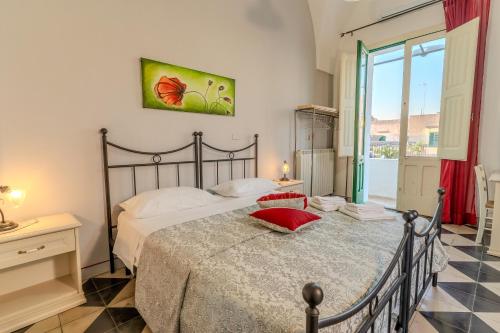 a bedroom with a bed with a red pillow on it at Antica Terrazza in Morciano di Leuca