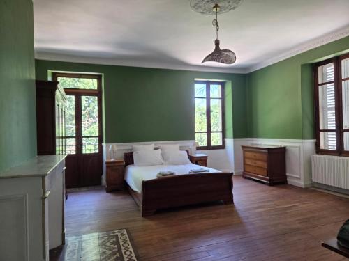 a bedroom with green walls and a bed in a room at Domaine de Lasserre in Lupiac