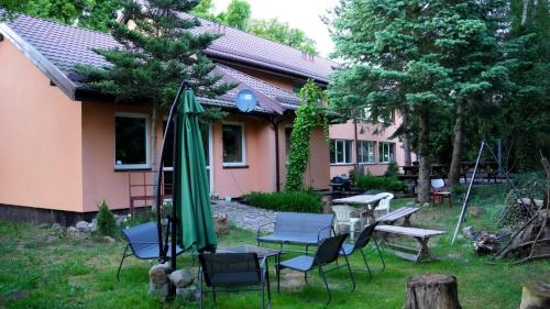 a house with a table and chairs and an umbrella at Pokoje gościnne „SEN” in Iława