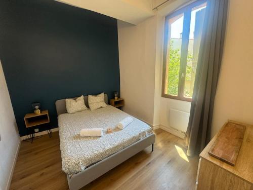 a bedroom with a bed and a large window at Le Nomad - Perpignan center in Perpignan
