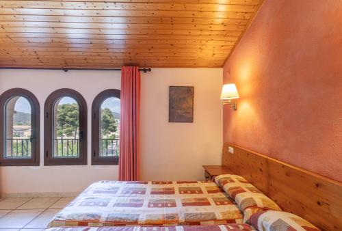 a bedroom with a bed in a room with windows at Els Castellers in Sant Pau dʼOrdal