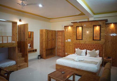 a bedroom with wooden walls and a bed and a table at Hotel Arijika View in Kullu Manali