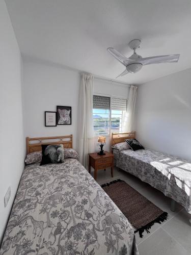 a bedroom with two beds and a ceiling fan at Eco Espacio Camaleón Verde 2 in Cartagena