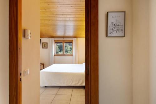 a bedroom with a bed and a window at Ball de Bastons in Avinyonet