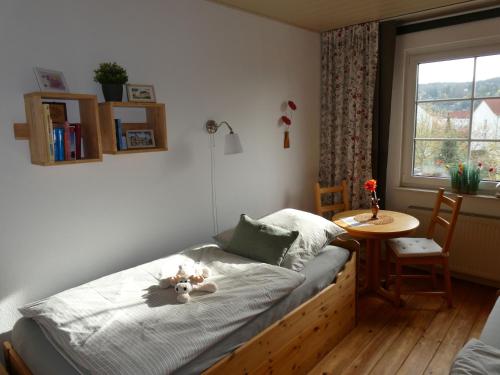 a bedroom with a bed with a table and a window at Ferienwohnung zum Riesenlöffel in Arnstadt