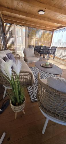 a porch with wicker chairs and a table and chairs at Mobile home Bokun sriće in Drage