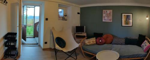 a living room with a couch and a tv at Maisonnette de vignes avec vue imprenable in Marvejols