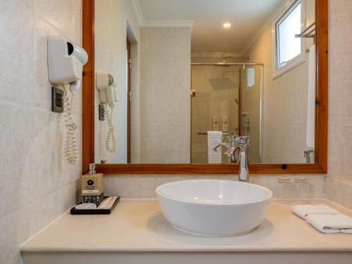 a bathroom with a white sink and a mirror at Kaani Village & Spa - Stay 3 Nights and Save 20 Percent on Spa and 10 Percent on Dining Until 31 October 2026 in Maafushi