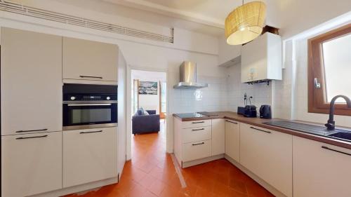 a kitchen with white cabinets and a stove top oven at L'atelier de la rue Mailly in Perpignan