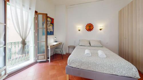 a bedroom with a bed and a desk and a window at L'atelier de la rue Mailly in Perpignan