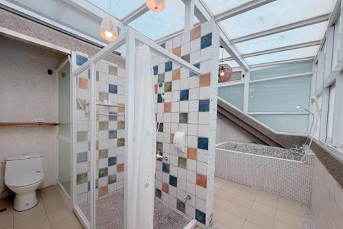 a bathroom with a toilet and a glass ceiling at Village Villa B&B in Zhuqi