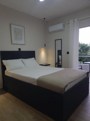a large bed in a bedroom with a window at Rhódia & Sun by Booking Kottas in Ixia