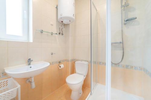 a bathroom with a toilet and a sink and a shower at Willa Promyk in Jastarnia