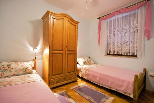 a room with two beds and a large wooden cabinet at Apartment Ivka in Poreč