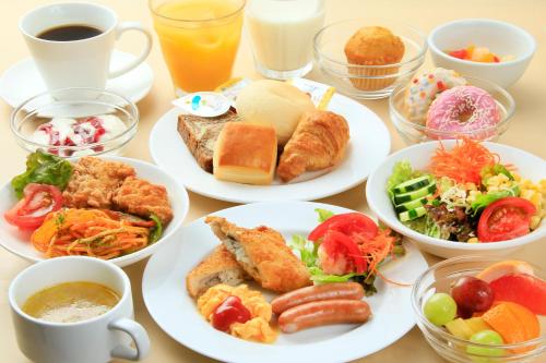 a table with plates of food and cups of coffee at Richmond Hotel Narita in Narita
