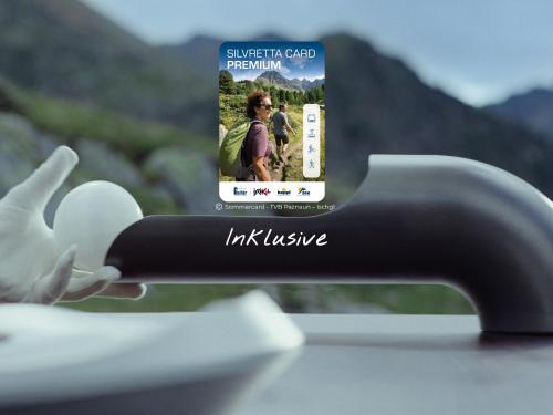 a close up of a remote control with a picture of a person at VAYA Residence Galtür Paznaun in Galtür