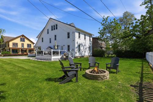 a yard with chairs and a fire pit in front of a house at Dragonfly Guest House-GOTL Strip in Geneva