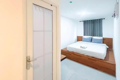 a bedroom with a bed and a glass door at Graha Martadinata Syariah Mitra RedDoorz in Tasikmalaya