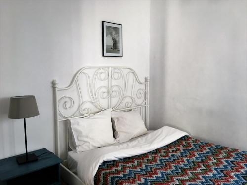 リスボンにあるCasa De Baixoのベッドルーム(白いベッド、大きなヘッドボード付)