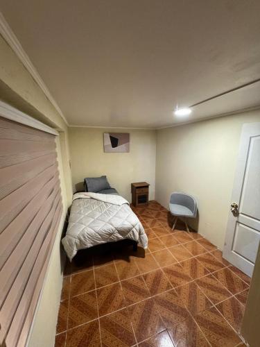 a bedroom with a bed in the corner of a room at Hostel Campus Lircay in Talca