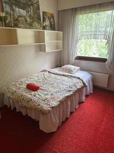 a bed in a bedroom with a red carpet at Guest room in Retro House in Turku