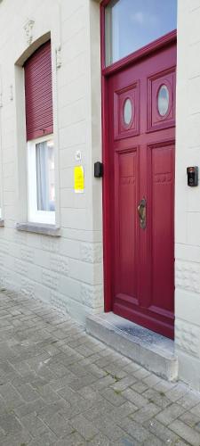 a red door on the side of a building at Wervik-94 in Wervik