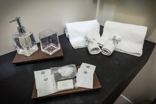a black table with towels and a bottle of soap at LuxurYenne in Cagliari