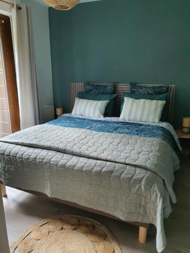 a bedroom with a large bed with blue walls at Au Doubs lac, Cosy 4 pers Terrasse ,Ski et Nature in Malbuisson