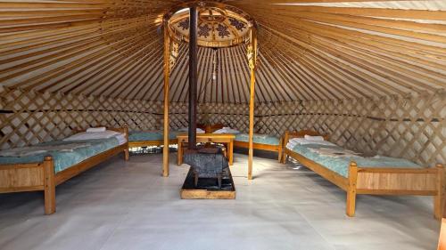a yurt with three beds and a stove in it at Blue Pearl - Khovsgol Lake in Khyaktil