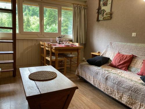 a living room with a bed and a table with a dining room at Appartement residence bec aigle in Le Lioran