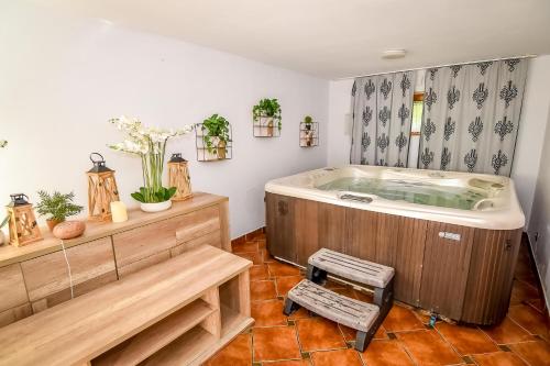 a bath tub in a room with a chair at Willa Anna Bukowina Jacuzzi & Sauna in Bukowina Tatrzańska