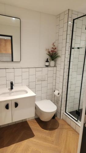 a white bathroom with a toilet and a sink at El Roi on NINE PALMS in Cape Town