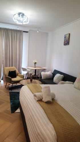 a bedroom with two beds and a table and a couch at El Roi on NINE PALMS in Cape Town