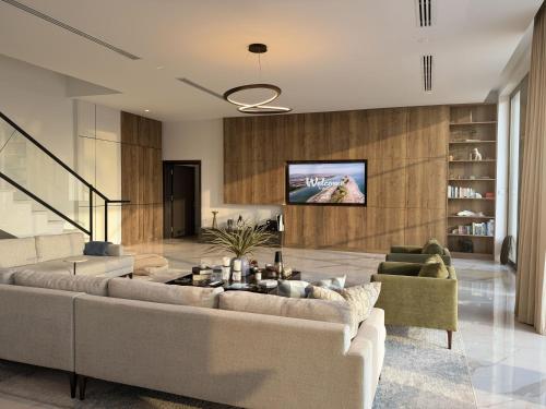 a living room with two couches and a tv at Villa 72 RAK in Ras al Khaimah