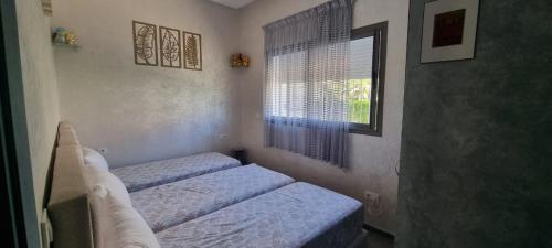 a bedroom with two twin beds and a window at Appart Ennakhil 4 avenue mohamed 6 in El Jadida