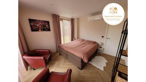 a small bedroom with a bed and a chair at De Bosanemoon with Sauna | 6 persons in Gasselte