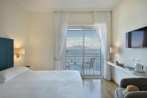 a hotel room with a bed and a view of the ocean at Boutique Hotel Regina in Sorrento
