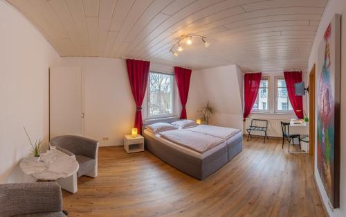 a large bedroom with a bed and a table at Hotel Am Park in Merseburg