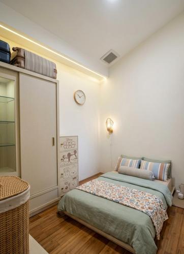 a bedroom with a bed and a clock on the wall at RR Travertine House Cikarang in Jatirarangan