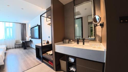a bathroom with a sink and a large mirror at Atour Hotel Karamay in Karamay