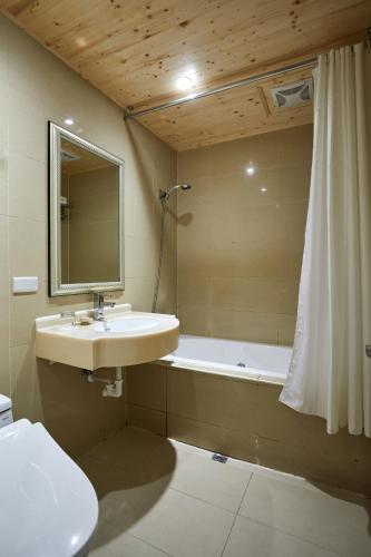 a bathroom with a sink and a tub and a shower at K Hotel Keelung in Keelung