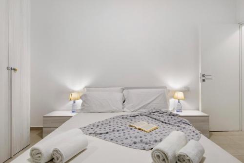 a white bedroom with a large bed with two lamps at Appartamento Zia Nena in Zelo Buon Persico