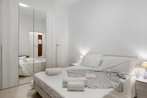 a white bedroom with a large bed and a mirror at Appartamento Zia Nena in Zelo Buon Persico
