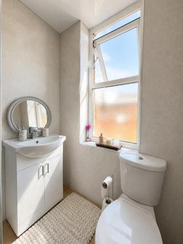 ein Badezimmer mit Toilette, Waschbecken und Fenster in der Unterkunft Cloud Quarters 3 in Amley