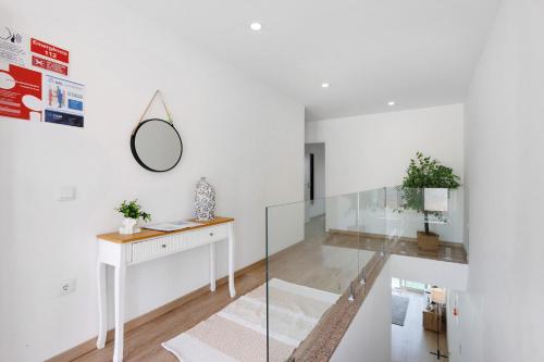 a white room with a desk and a mirror at Manuel'shouse in Vila Nova de Gaia